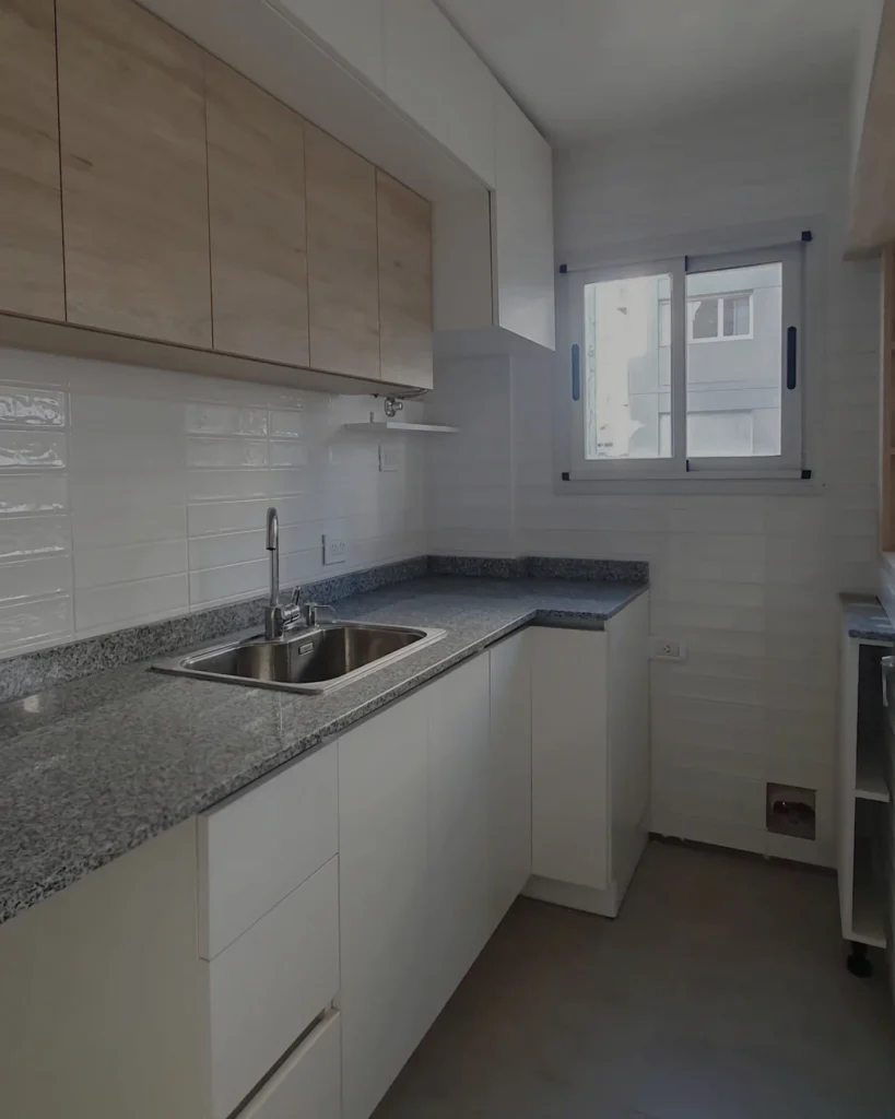 Cocina a medida en melamina símil roble y blanco con mesada de granito, proyecto Alsina en Mar del Plata