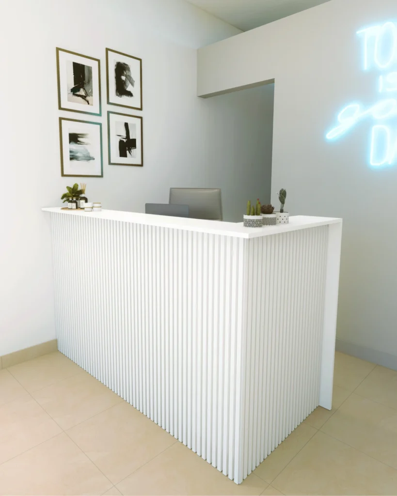 Mostrador de recepción blanco con cartel de neón del local