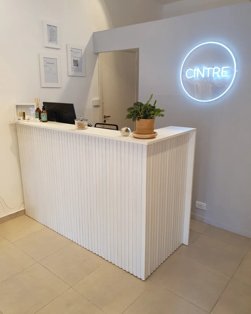 Mostrador de atención iluminado por el cartel de neón Cintre