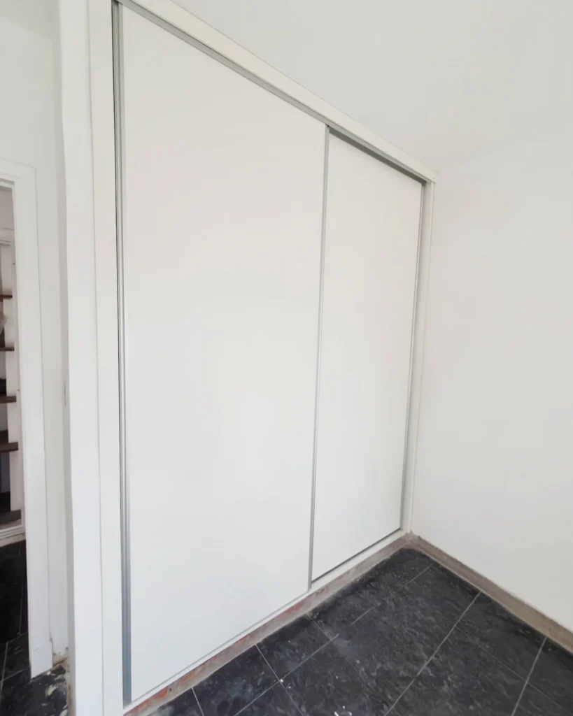 Placard terminado con puertas corredizas y marco blanco