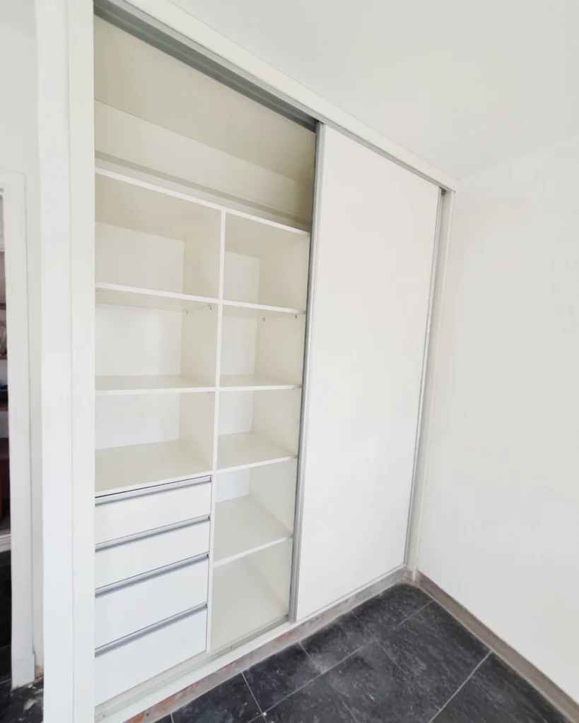 Interior del placard con estantes, cajonera y barral para colgar