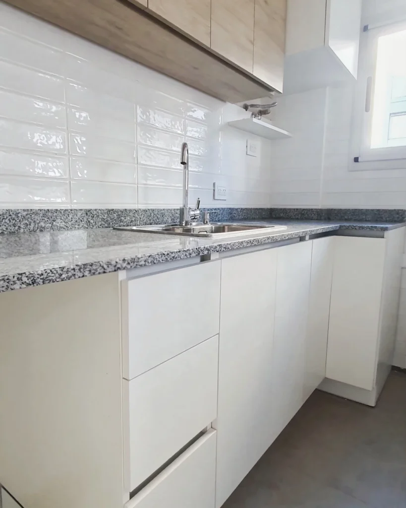 Detalle del bajo mesada blanco y la mesada de granito gris
