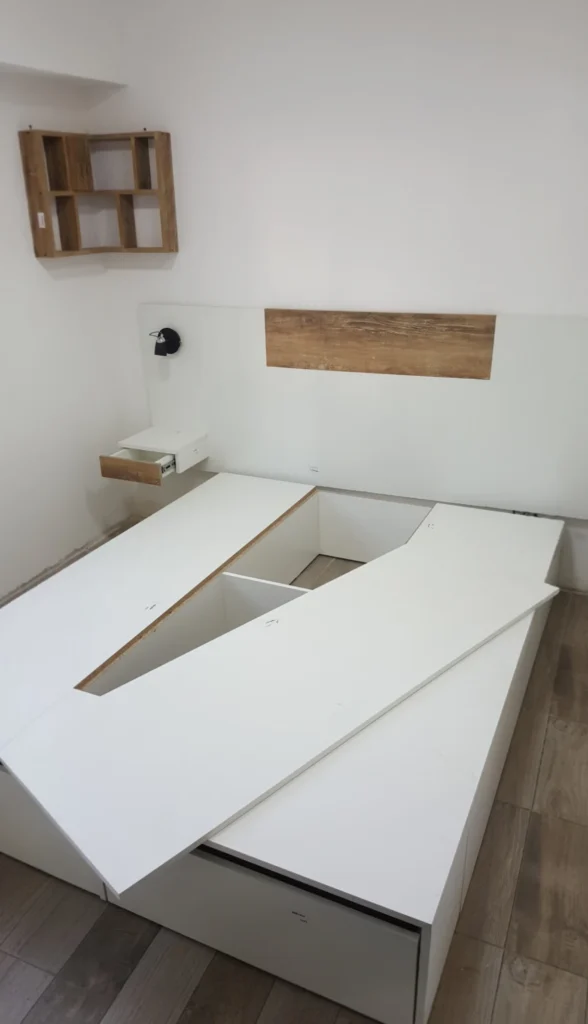 Cama box con la tapa rebatible abierta, mostrando el baúl de guardado