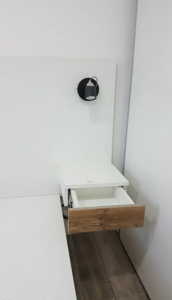 Mesa de luz flotante con cajón símil madera y aplique de pared